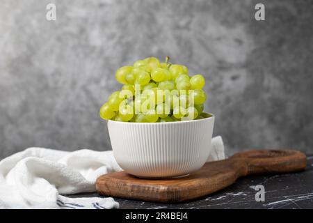 https://l450v.alamy.com/450v/2r4bej4/green-grapes-in-bowl-organic-farm-products-tasty-green-grape-bunches-on-dark-background-2r4bej4.jpg