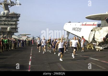 US Navy  Crew members run a race on the flight deck aboard the nuclear-powered aircraft carrier USS Nimitz (CVN 68) while underway in the Persian Gulf. Stock Photo