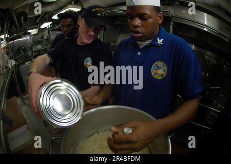 US Navy  Culinary Specialist 3rd Class left, and Aviation Ordnanceman Airman whip mashed potatoes in the wardroom galley aboard the conventionally powered aircraft carrier USS Kitty. Stock Photo