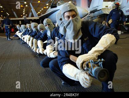 US Navy  Sailors assigned to Repair Locker One Bravo stand ready to battle a simulated fire. Stock Photo