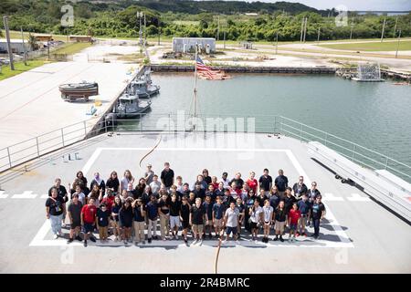 APRA HARBOR, Guam (Jan. 12, 2023)— Students from Cmdr. William C. McCool Middle School pose for a group photo following a tour of the submarine tender USS Emory S. Land (AS 39), Jan. 12. Emory S. Land is tasked to provide expeditionary intermediate level maintenance and repairs, as well as provide hotel services and logistics support to deployed guided-missile and fast-attack submarines. Stock Photo