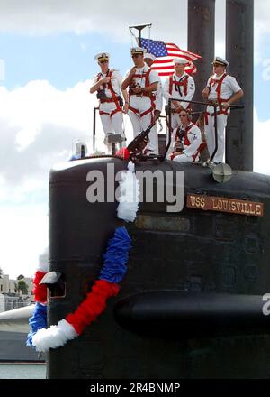 U.S. Naval crew members of a submarine stow away below deck a torpedo ...