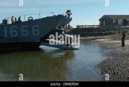 US Navy  A U.S. Marine directs a humvee out of Landing Craft, Utility One Six Six Six (LCU-1666) assigned to Amphibious Craft Unit One (ACU-1). Stock Photo