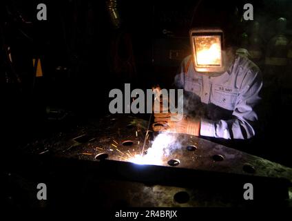 US Navy Hull Technician Fireman practices welding techniques aboard the ...