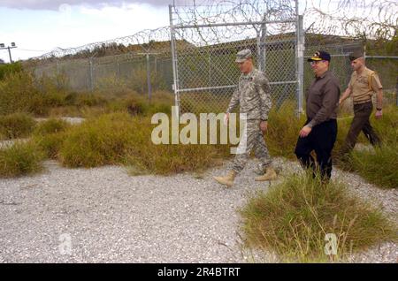 US Navy  Led by Joint Task Force Guantanamo Commanding General Maj. Gen. Jay Hood, Secretary of the Navy (SECNAV), Dr. Donald C. Winter, inspects the heavily overgrown remains of Camp X-ray. Stock Photo