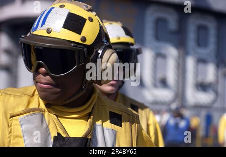 US Navy  Aviation Boatswain's Mate Airman directs a hose team during a flight deck fire drill aboard the nuclear-powered aircraft carrier USS Nimitz (CVN 68). Stock Photo