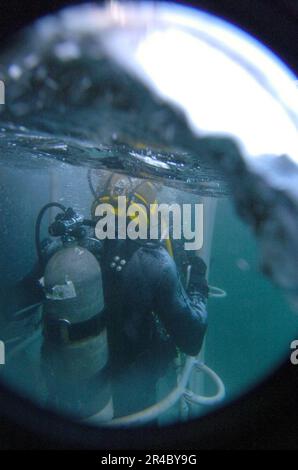 US Navy  A U.S. Navy diver is lowered into the water during a series of training dives during a prescreening to master diver qualifications aboard the Military Sealift Command fleet ocean tug USNS Navajo (T-AT. Stock Photo