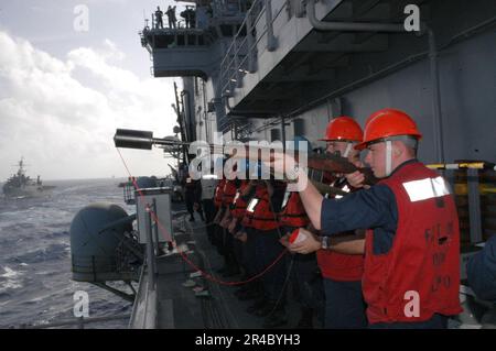 US Navy  Gunner's Mate Seaman prepares to shoot an M-14 rifle with shot line adapter to the Military Sealift Command (MSC) underway replenishment oiler USNS Walter S. Diehl (T-AO 189). Stock Photo