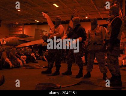 US Navy  Sailors gather in hangar bay two for a lecture on fire hose team responsibilities during a general quarters (GQ) drill aboard the Nimitz-class aircraft carrier USS Abraham Lincoln (CVN 72). Stock Photo