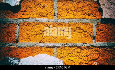 Red brick wall with pieces of peeling plaster. Vintage camera filter added to image Stock Photo