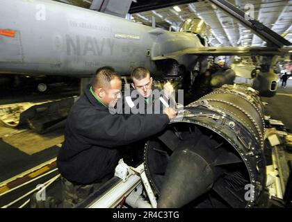 US Navy  Aviation Structural Mechanic Airman left, and Aviation Machinist's Mate Third Class assigned to Electronic Attack Squadron One Three One (VAQ-131) perform maintenance. Stock Photo