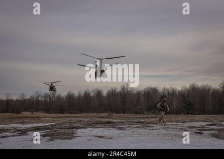 A U.S. Marine with 1st Battalion, 10th Marine Regiment, 2d Marine Division prepares to set security during exercise Rolling Thunder on Fort Drum, New York, March 27, 2023. This exercise is a live-fire artillery event that tested the 10th Marine Regiment’s ability to operate in a simulated littoral environment against a peer threat in a dynamic and multi-domain scenario. Stock Photo