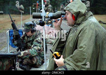 US Navy  SAFS instructor right, checks the accuracy of 26 students who took part in the small arms firing school sponsored by the Washington National Guard at Fort Lewis, Wash. Stock Photo