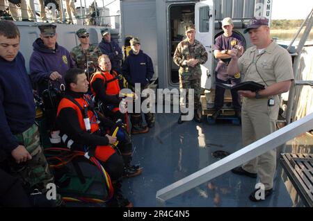 US Navy  Master Diver candidate Senior Chief Damage Controlman assigns positions during the next exercise to other fellow candidates before their upcoming mission aboard Landing Craft Unit (LCU-16. Stock Photo