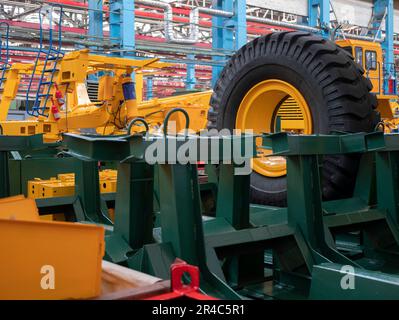 Workshop of machine-building plant, selective focus. Huge wheel and different metal components and assemblies Stock Photo