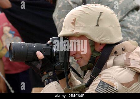 US Navy U.S. Navy Photographer's Mate 1st Class assigned to Fleet Combat Camera Group Pacific, photographs U.S. Army Soldiers from the Dark Knights of Delta Company (cropped) Stock Photo