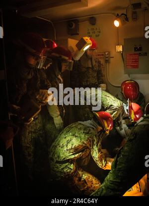 Recruits participate in Battle Stations inside USS Trayer (BST 21) at Recruit Training Command (RTC). Trayer, more commonly referred to as 'Battle Stations,' is the crucible event that recruits must pass prior to graduation, testing their knowledge and skills in basic seamanship, damage control, firefighting and emergency response procedures. Boot camp is approximately 10 weeks and all enlistees into the U.S. Navy begin their careers at the command. Training includes five warfighting competencies of firefighting, damage control, seamanship, watchstanding, and small arms handling and marksmansh Stock Photo