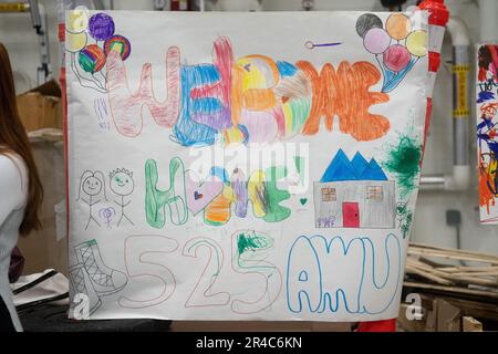 A welcome home poster drawn by the children of Airmen from the 525th Fighter Squadron Expeditionary team is displayed in Hanger 25 on Joint Base Elmendorf-Richardson, Alaska, April 8, 2023. “The 525 Bulldogs deployed to Kadena AB the first week of November to support PACAF’s efforts to bring more advanced fighter aircraft forward to the western pacific while Kadena Air Base’s F-15C Eagles began divesting,” said Lt. Col. Matthew Tromans, 525th Fighter Squadron commander. Stock Photo
