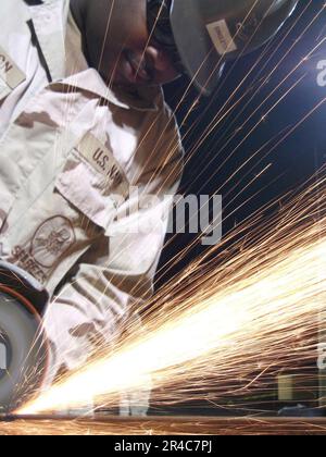 US Navy  Construction Electrician 2nd Class assigned to Naval Mobile Construction Battalion Seven (NMCB-7) cuts a breaker panel stand prior to installing it at the Trailer Park 3 project. Stock Photo