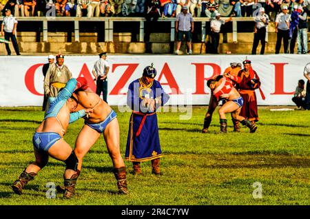 A referee checks his watch. Mongolian wrestlers, Naadam Festival, National Stadium, Ulaanbaatar, Mongolia. July, 2009. © Kraig Lieb Stock Photo