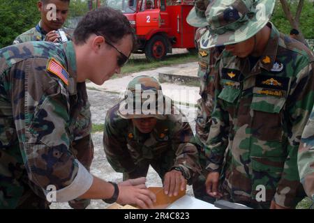 US Navy Electronics Technician 1st Class works with Royal Thai Navy (RTN) EOD personnel while preparing an explosive charge which will be used to demolish a vehicle transported from the United Stock Photo