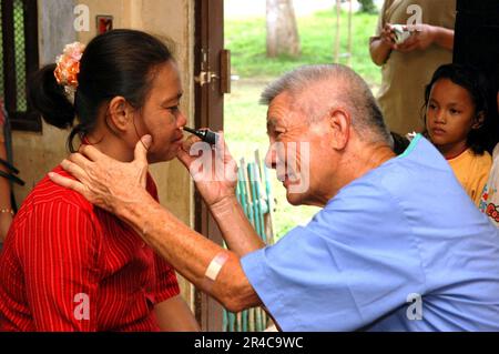 US Navy  a doctor with Aloha Medical Mission, examines a woman at Camp Batista during a Medical and Dental Civil Action Project hosted by the U.S. Military Sealift Command (MSC) Hospital ship USN. Stock Photo