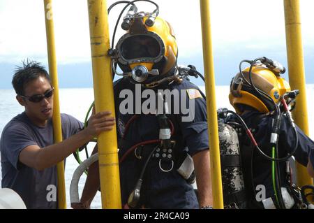 US Navy Master Sgt. from the Republic of Singapore Navy (RSN) stage handles Gunner's Mate 2nd Class and Lt. RSN, after they conducted a dive Stock Photo