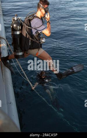 US Navy  Cpl. from the Republic of Singapore Navy (RSN) steps off the side of rescue and salvage ship USS Salvor (ARS 52). Stock Photo