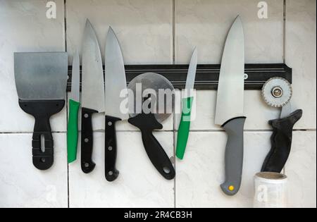 https://l450v.alamy.com/450v/2r4cb3h/chiefs-knives-and-other-tools-hanging-on-magnetic-rack-in-a-kitchen-of-restaurant-2r4cb3h.jpg