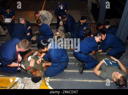 US Navy  Ship's Hospital Corpsman and stretcher-bearers report to a mass casualty drill in the well deck aboard the amphibious assault ship USS Iwo Jima (LHD 7). Stock Photo