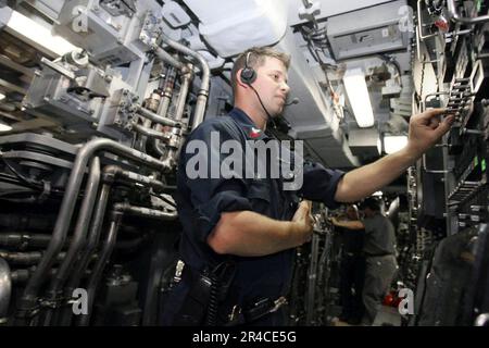 US Navy Petty Officer 1st class assists in a shipboard test evolution aboard the Virginia-class attack submarine USS Texas (SSN 775) Stock Photo