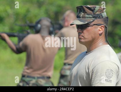 US Navy Petty Officer 1st Class observes Sailors during a M16A1 qualification at the Naval Base Guam gun range Stock Photo