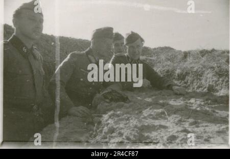 SS Photographer Ahrens captures the intensity and brutality of the Kavallerie operations in Russia during  May and June 1943, providing a haunting glimpse into the grim realities of war through his lens. Senior officers in dress uniforms with awards, wounded soldiers in war hospital; soldiers with Russian civilians; awards ceremonies, landscapes, saw mill, terrain table exercise, fighting positions, soldiers relaxing and swimming, infantry squad field training, propaganda material being handed out to Russian civilians, burning village, assault gun unit, field barracks scenes. Images depicting Stock Photo