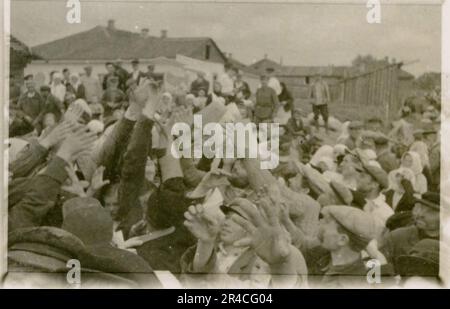 SS Photographer Ahrens captures the intensity and brutality of the Kavallerie operations in Russia during  May and June 1943, providing a haunting glimpse into the grim realities of war through his lens. Senior officers in dress uniforms with awards, wounded soldiers in war hospital; soldiers with Russian civilians; awards ceremonies, landscapes, saw mill, terrain table exercise, fighting positions, soldiers relaxing and swimming, infantry squad field training, propaganda material being handed out to Russian civilians, burning village, assault gun unit, field barracks scenes. Images depicting Stock Photo