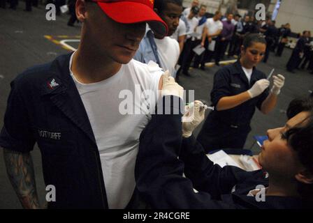 US Navy  Damage Controlman 3rd Class receives his annual influenza immunization shot. Stock Photo