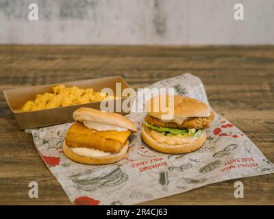 Fish and Chicken Burger with a tray of cheese fries Stock Photo