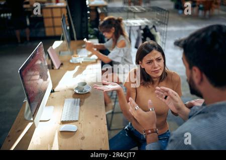 Employees sitting in creative moden office, manager talking with female worker, talking about project, woman feeling confused. Business, temawork, mee Stock Photo