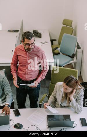 The boss telling his employees about their new job for the client at the office Stock Photo