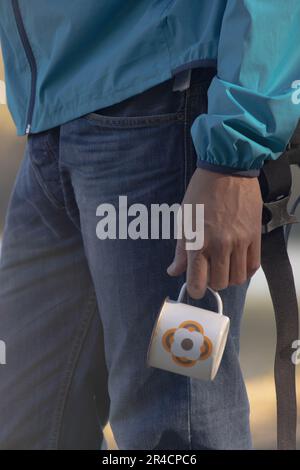 Cup of coffee detail of traveler man at lake in autumn Stock Photo