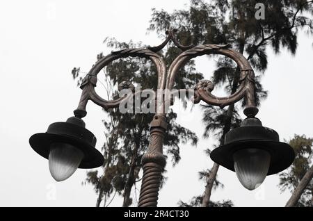 Old vintage street lamp on the road at night. Old vintage streetlight on on park Stock Photo