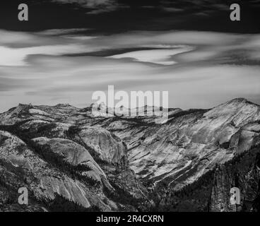 Clouds Smear Across The Sky Over The Bright Granite of Yosemite with high contrast black and white effect Stock Photo