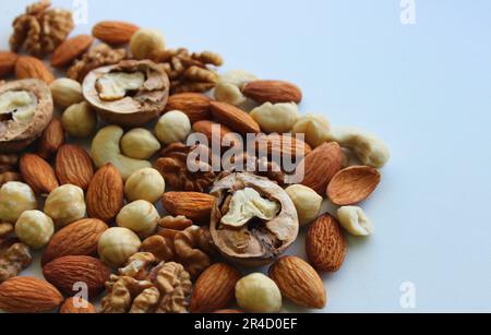 Triangle of scattered nuts of different varieties on a white background concept for backgrounds Stock Photo