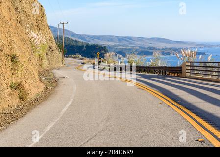 Empty winding coast road on a sunny autumn day Stock Photo