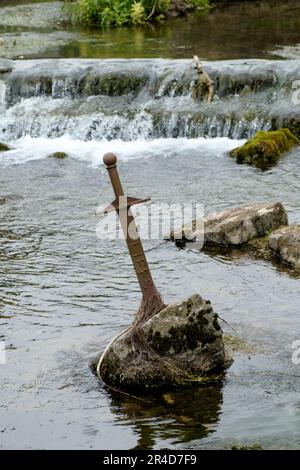 Around Cheddar Gorge a tourist attraction in Somerset UK. Replica of excalibur the sword in the stone in the river the Cheddar Yeo Stock Photo