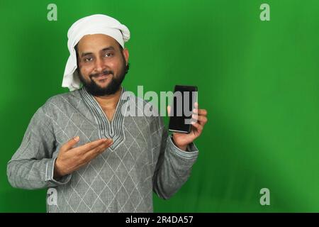Indian Young Farmer Showing His Mobile on Right Hand In Green Screen, Copy Space Stock Photo