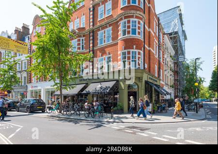 People out and about In Marylebone High Street and taking refreshments seated at pavement tables outside Le Pain Quotidien restaurant. London, England Stock Photo