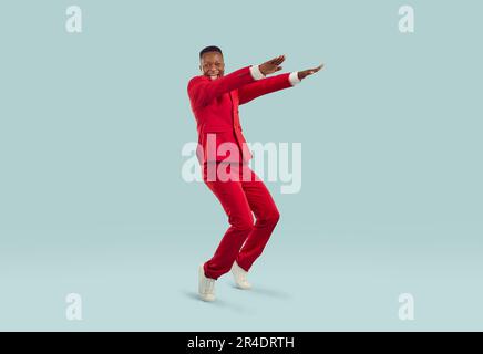 Cheerful excited stylish african american man having fun on pastel gray background. Stock Photo