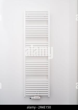 Battery for drying towels in the bathroom. Radiator on the wall. Stock Photo