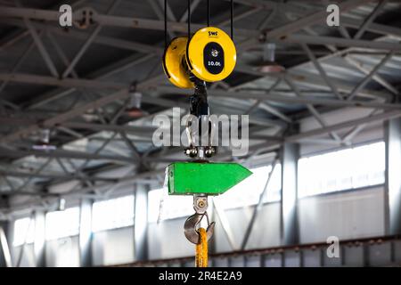 Crane hook close-up, in focus. Workshop interior on background, blurred. Stock Photo