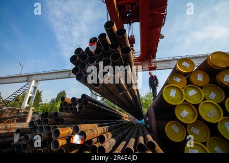 Podolsk, Moscow province - August 02, 2021: Pipes warehouse. Worker load pipes with bridge crane Stock Photo